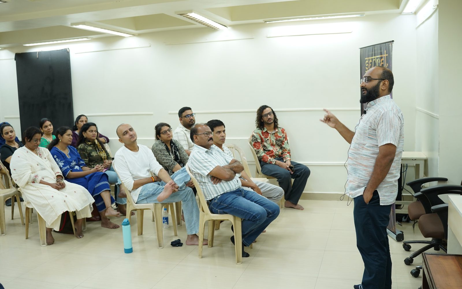 A practitioner leading a workshop session with a seated group