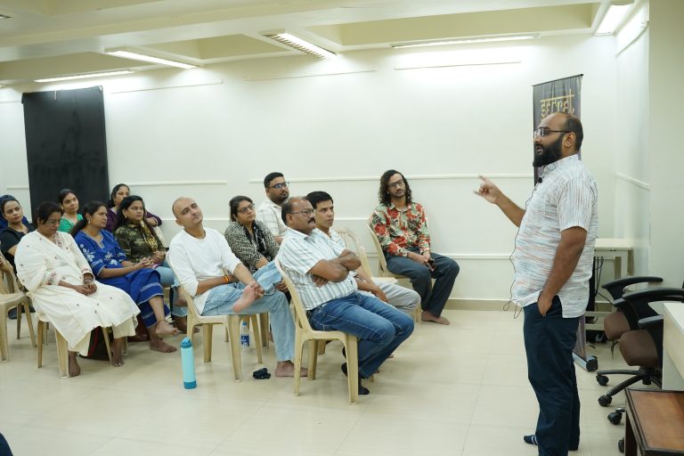 A practitioner leading a workshop session with a seated group