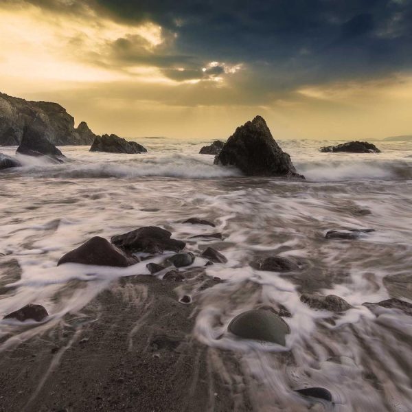Dramatic rock formations along a coastline at dusk
