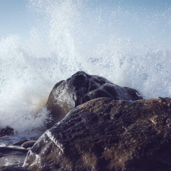 A wave breaking against a rock, symbolic of releasing tension
