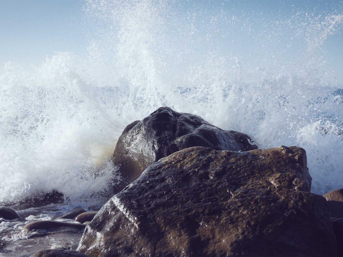 A wave breaking against a rock, symbolic of releasing tension